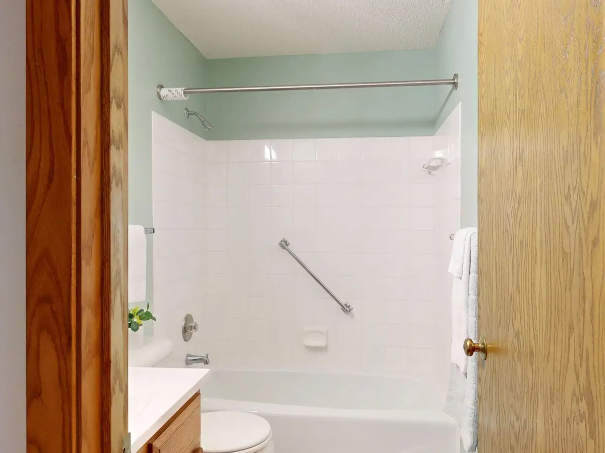 Bathroom with a tub, tile walls and a grab bar (Walk-in tub with shower safety, standing and seated)